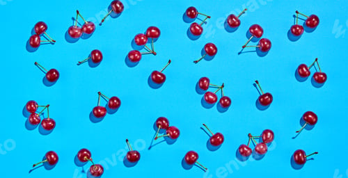 Red Cherries Arranged on a Vibrant Blue Surface