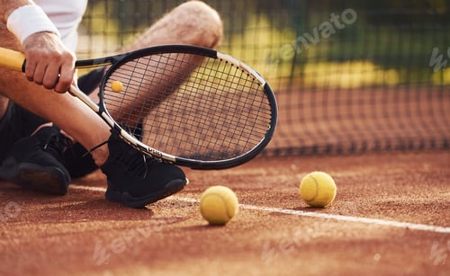 Preview: Close up view of senior man in white shirt and black sportive shorts that is on tennis court