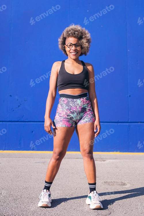 Preview: smiling african sportswoman looking at camera
