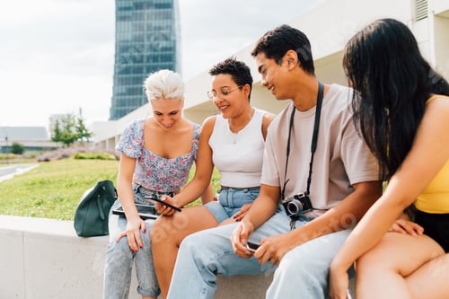 Preview: Group of multiethnic young people outdoor using smartphone