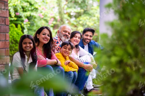 Preview: Indian family enjoying outdoor bonding time on steps during weekend relaxation