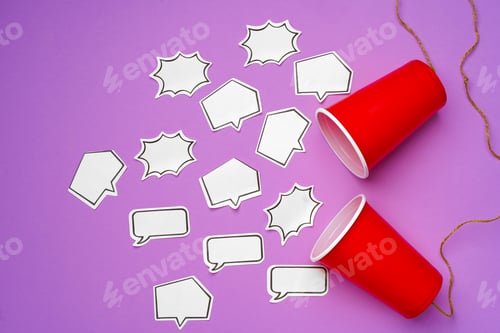 Preview: Toy telephone made of plastic cups and string with speech bubbles on purple background