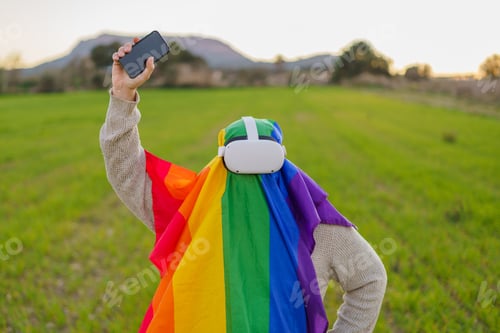 Preview: Man with virtual reality glasses and an LGBT flag raising his phone