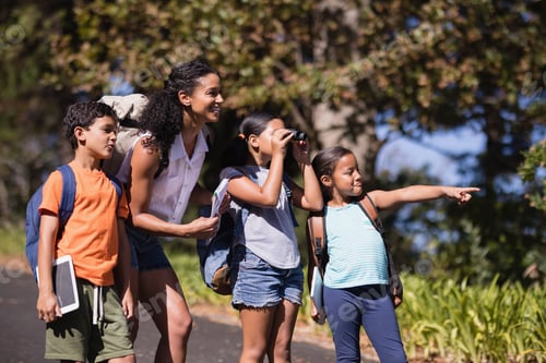 Preview: Girl pointing away with friends and teacher on street