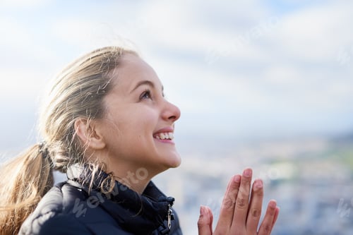 Preview: Cropped shot of an attractive young woman standing with her hands together in prayer outside