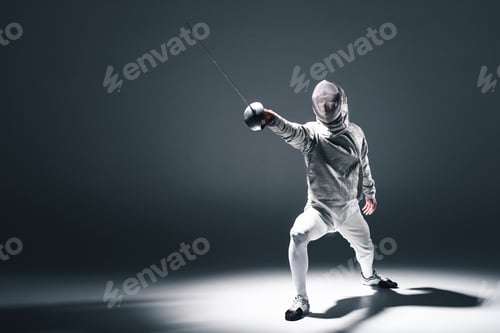 Preview: Professional fencer in fencing mask with rapier standing in position isolated on grey