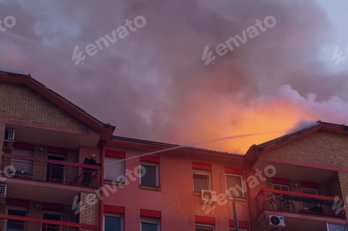 Preview: Firefighter on a balcony put out a fire in a burning building