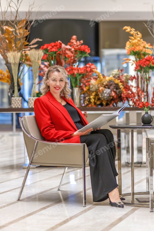 Preview: A blonde in a stylish red business suit in the business center. The concept of a business woman
