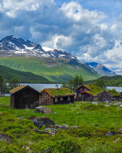 Preview: Charming Norwegian Cabins Nestled in Lush Green Landscape Under Dramatic Clouds