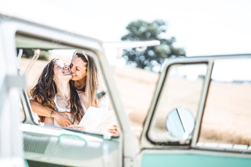 Preview: two attractive woman who looks at the map next to her van