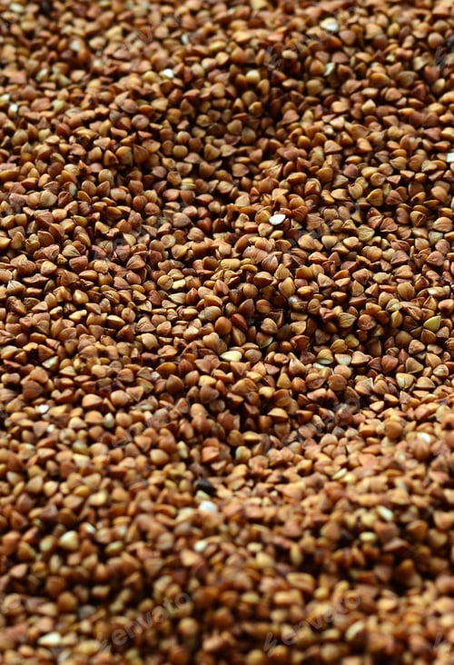 Preview: Background texture of a large pile of buckwheat. Many buckwheat grains close-up in daylight
