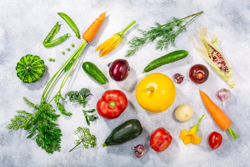 Preview: Fresh select seasonal vegetables on light textured backdrop, top view
