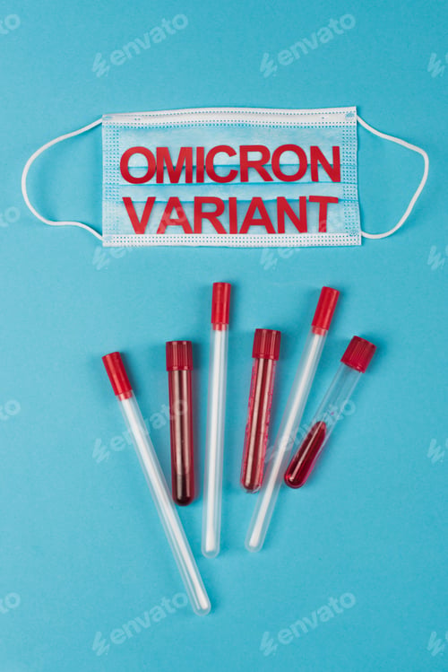 Preview: Top view of medical mask with omicron variant near test tubes and cotton swabs on blue background