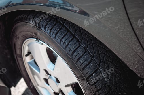 Preview: Wheel with a wet tire of a grey car