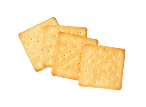 Preview: Many crispy crackers isolated on white, top view. Delicious snack