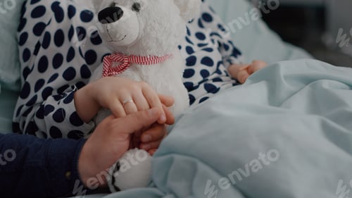 Preview: Closeup of father holding daughter hand after suffering medical surgery during sickness recovery
