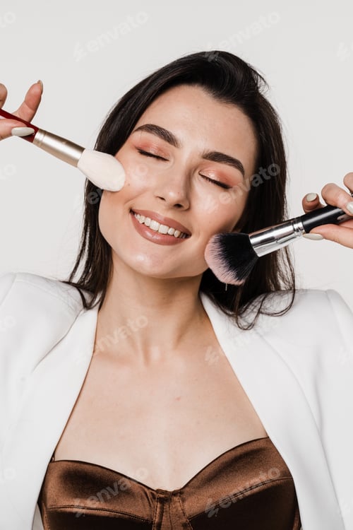 Preview: Smiling Woman Applying Makeup with Brushes Indoors
