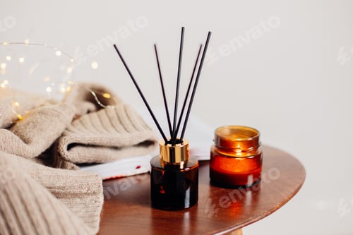 Preview: Home aroma fragrance diffuser and burning candles on wooden table in the bedroom