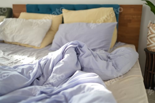 Preview: Comfort and Untidy Bed with Pillows and Duvet. The Pastel Color themed sheets and pillows were ruine
