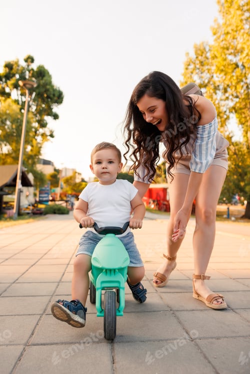 Preview: Mother teaching toddler son how to ride a bike