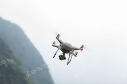 Preview: White drone with camera flying in spring mountains