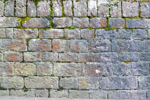 Preview: Granite stonewall with green grass background texture.