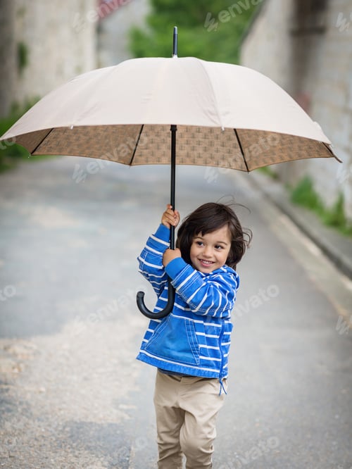Preview: Little eastern handsome baby boy playing with umbrella outdoor