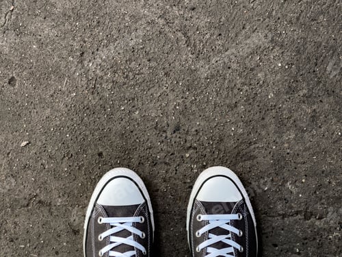 Preview: Overhead shot of black sneakers on an asphalt ground - copy space and background