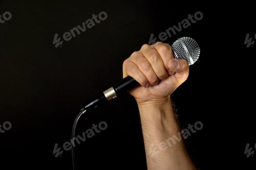 Preview: Male hand with microphone isolated on black