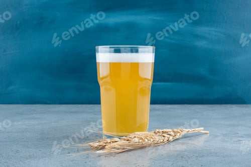 Preview: A glass of delicious beer and wheat on gray background
