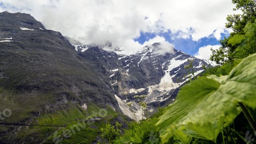 Preview: Beautiful scenery of a mountainous landscape covered with snow under a cloudy sky