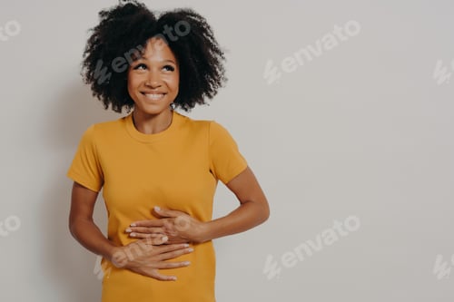 Preview: Happy african american woman laughing out loud at some hilarious joke, keeping hands on stomach