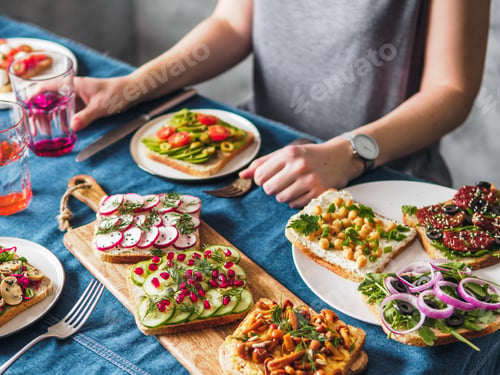 Preview: Female hands on vegetarian tablesettings