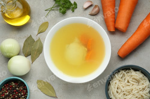 Preview: Delicious chicken bouillon and ingredients on light grey textured table, flat lay