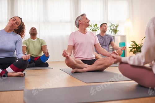 Preview: Group With Teacher Sitting On Exercise Mats Stretching In Yoga Class Inside Community Center