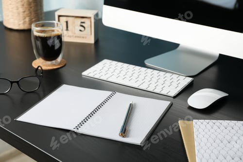 Preview: Workplace with computer, glasses and calendar on black wood table, close up