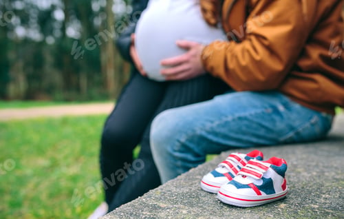 Preview: Closeup of small baby sneakers over bench