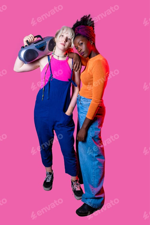 Preview: Two young diverse women holding boombox posing confident isolated background