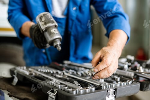 Preview: Mature technician or repairman taking one of iron nozzles for technical drill