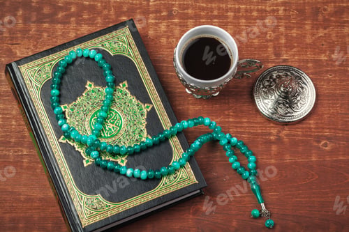 Preview: Holy Quran with beads over wooden background close up