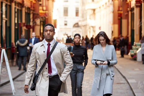 Preview: Millennial business people walking in a London street, front view