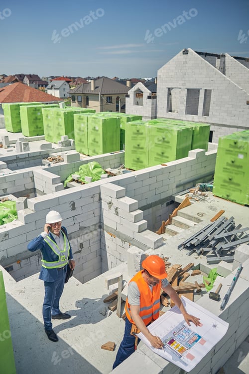 Preview: Contractor standing behind a civil engineer outside