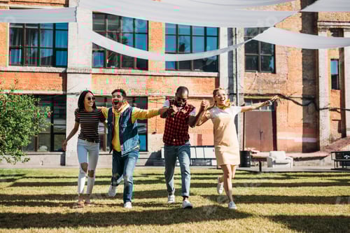 Visualização: jovens amigos multiculturais de mãos dadas enquanto se divertem juntos no dia de verão
