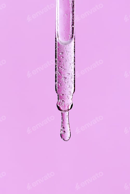 Preview: serum pipette close-up with falling drop on pink background