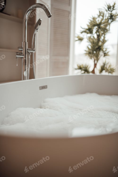Preview: Luxury interior of big bathroom at modern african style with oval bathtub in natural lighting