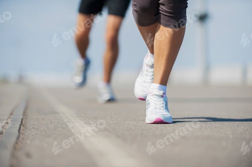 Preview: People running. Close-up image of woman and man running along the running track