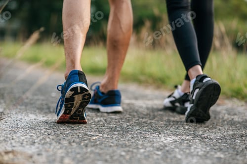 Preview: Runner woman and man feet running on road closeup on shoe. Sports healthy lifestyle concept.