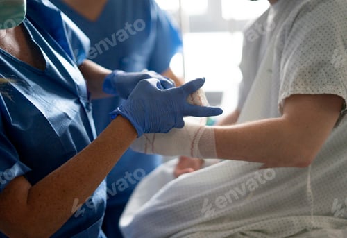 Preview: Nurse bandaging patient's arm in hospital room