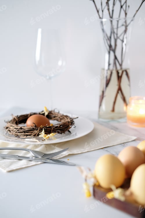 Preview: Beautiful Easter table setting with Easter wreath, egg and decorative nest.