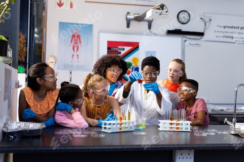 Preview: Diverse female teacher and school children doing an experiment in chemistry class